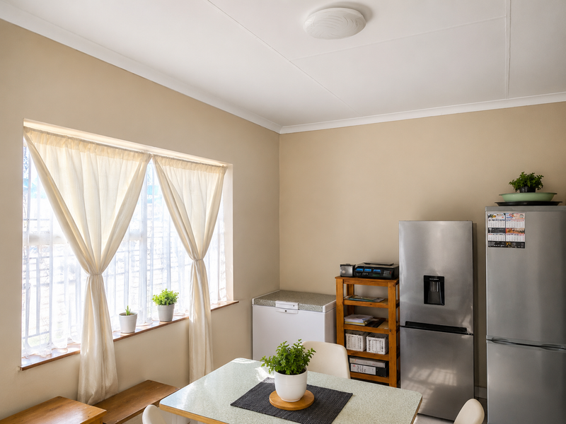 A functional kitchen area featuring a large window with natural light, neutral wall tones, and space for essential appliances.