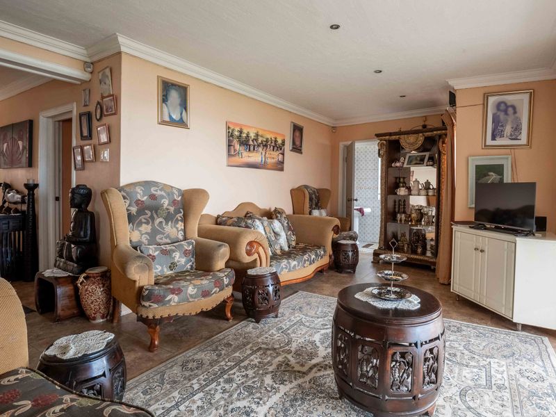 A comfortable living room featuring tiled flooring, coving, and recessed ceiling lights, providing a functional and well-maintained space for relaxation.