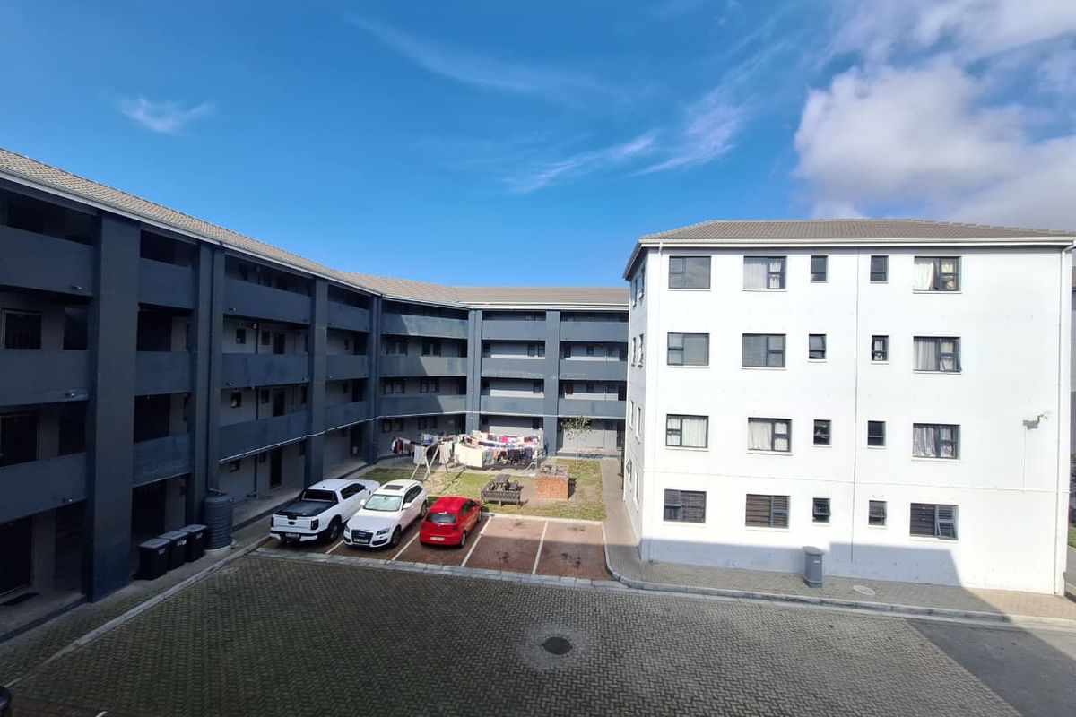An elevated view of the apartment complex courtyard featuring paved parking areas and multi-story residential building facades.