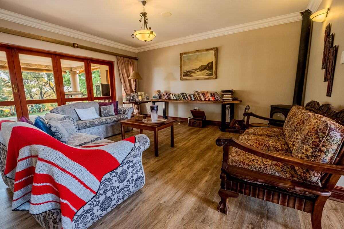 Spacious living room featuring wood-look laminate flooring, a wood-burning fireplace, and large wooden sliding doors providing access to the outdoor area.