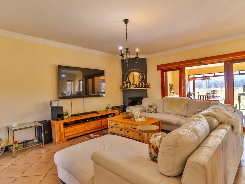 Spacious living room featuring tiled flooring, a central fireplace, and large sliding glass doors providing access to the outdoor area.