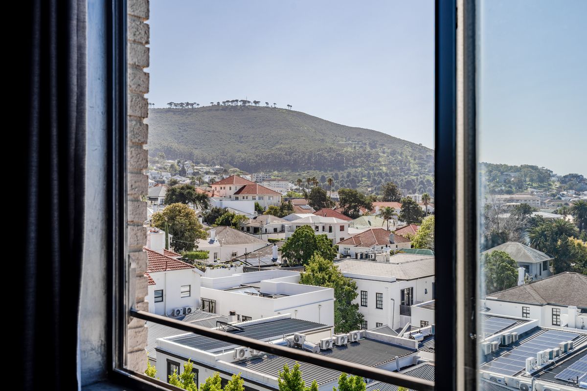 A clear, elevated view of the surrounding residential neighborhood and mountain landscape captured through a window.