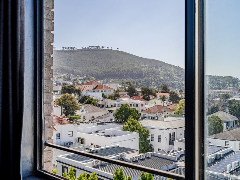 A clear, elevated view of the surrounding residential neighborhood and mountain landscape captured through a window.