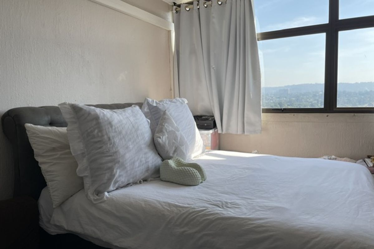 A bedroom featuring a large window with natural light and elevated views, providing a bright and airy atmosphere.