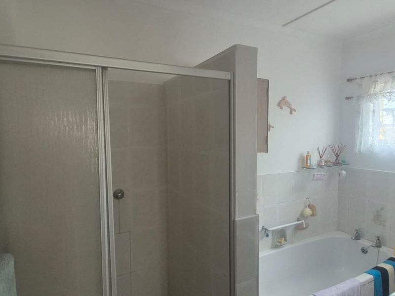 A functional bathroom featuring a separate shower enclosure and a bathtub with tiled wall finishes.