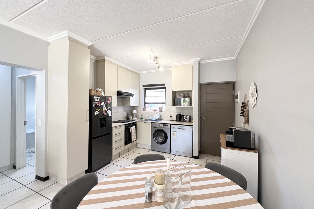 Functional kitchen featuring built-in cabinetry, integrated appliances, tiled flooring, and a tiled backsplash, offering a practical layout for daily cooking and dining.