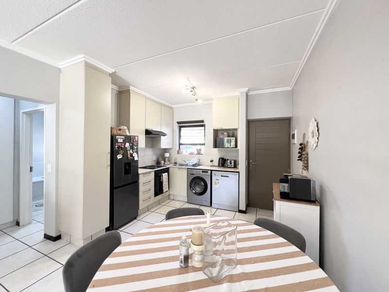Functional kitchen featuring built-in cabinetry, integrated appliances, tiled flooring, and a tiled backsplash, offering a practical layout for daily cooking and dining.
