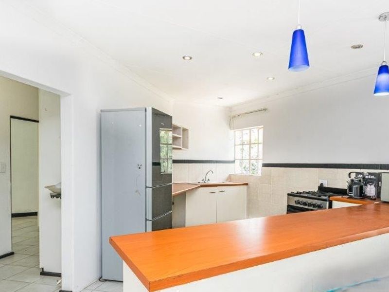 Functional kitchen featuring a breakfast bar, built-in cabinetry, gas stove, and tiled backsplash, offering a practical layout for daily meal preparation.
