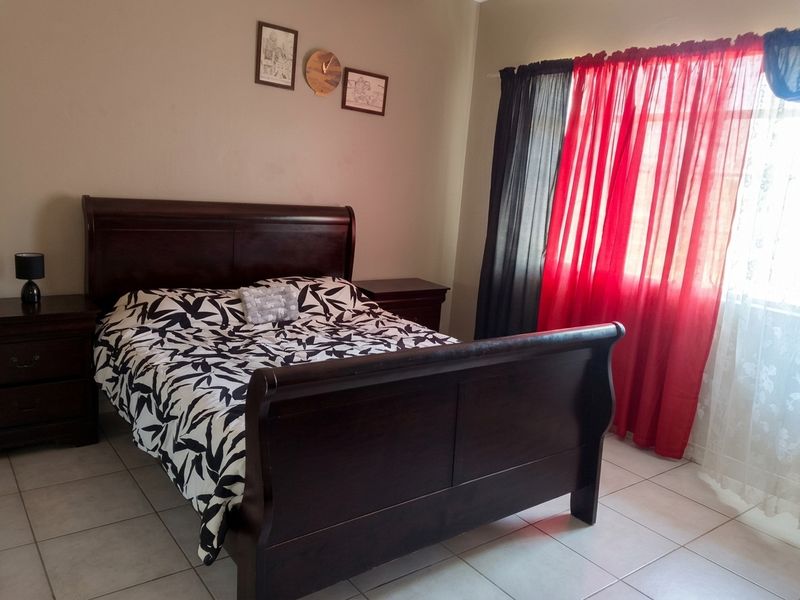 A functional bedroom featuring neutral wall tones and durable tiled flooring, providing a comfortable and practical living space.