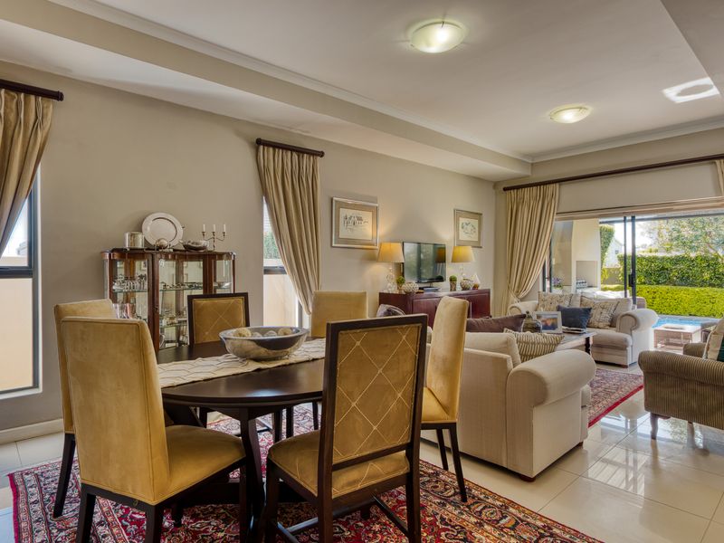 Spacious open-plan living and dining area featuring tiled floors, recessed lighting, and large sliding glass doors providing seamless access to the outdoor patio.