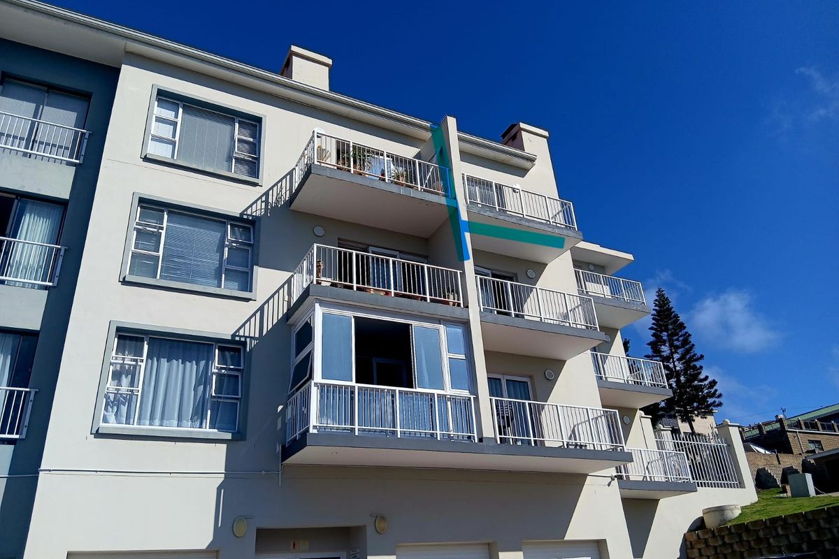 Rear elevation of a multi-story apartment building featuring private balconies with metal railings and ground-level garage access.