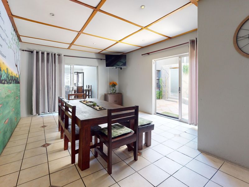 Dining room featuring tiled flooring, a coffered ceiling with recessed lighting, and sliding glass doors providing access to an outdoor area.