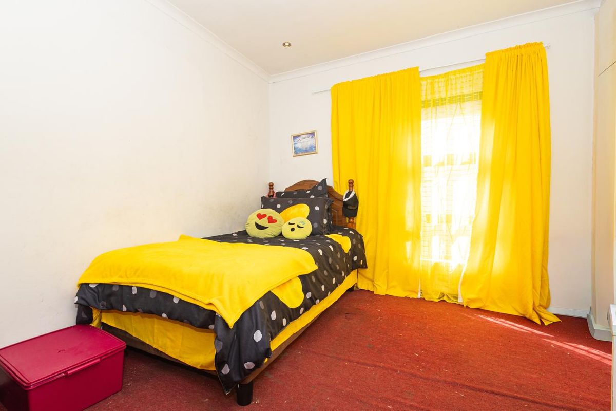 A bedroom featuring recessed downlighting and cove cornicing, currently finished with worn carpeting and requiring cosmetic updates to improve the overall aesthetic.