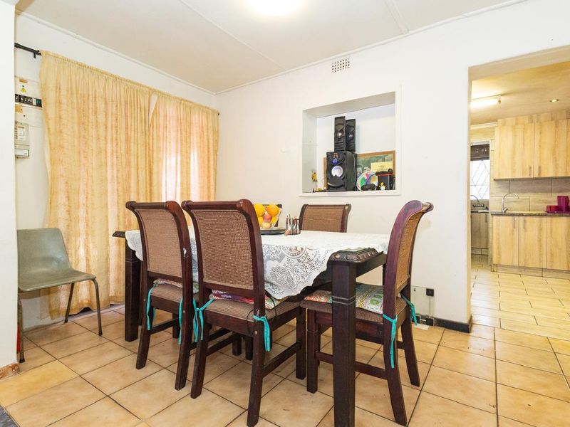Dining area featuring tiled flooring and a wall niche, with an open transition into the adjacent kitchen space.