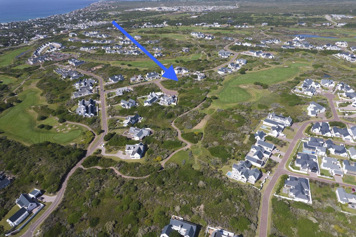 An aerial view of a residential estate situated within a coastal golf course landscape, highlighting the property location and surrounding environment.