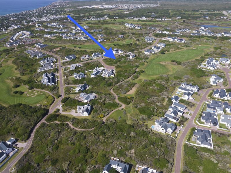 An aerial view of a residential estate situated within a coastal golf course landscape, highlighting the property location and surrounding environment.