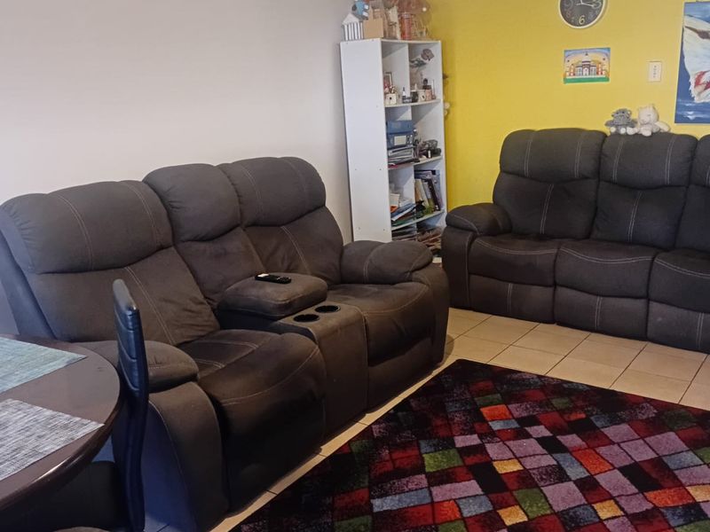 A living room area featuring ceramic floor tiles and a bright yellow accent wall.