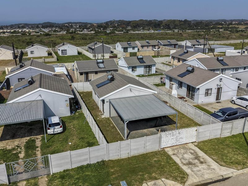 Aerial view of a residential estate featuring detached houses with tiled roofs, solar geysers, private carports, and enclosed garden spaces with boundary walls.