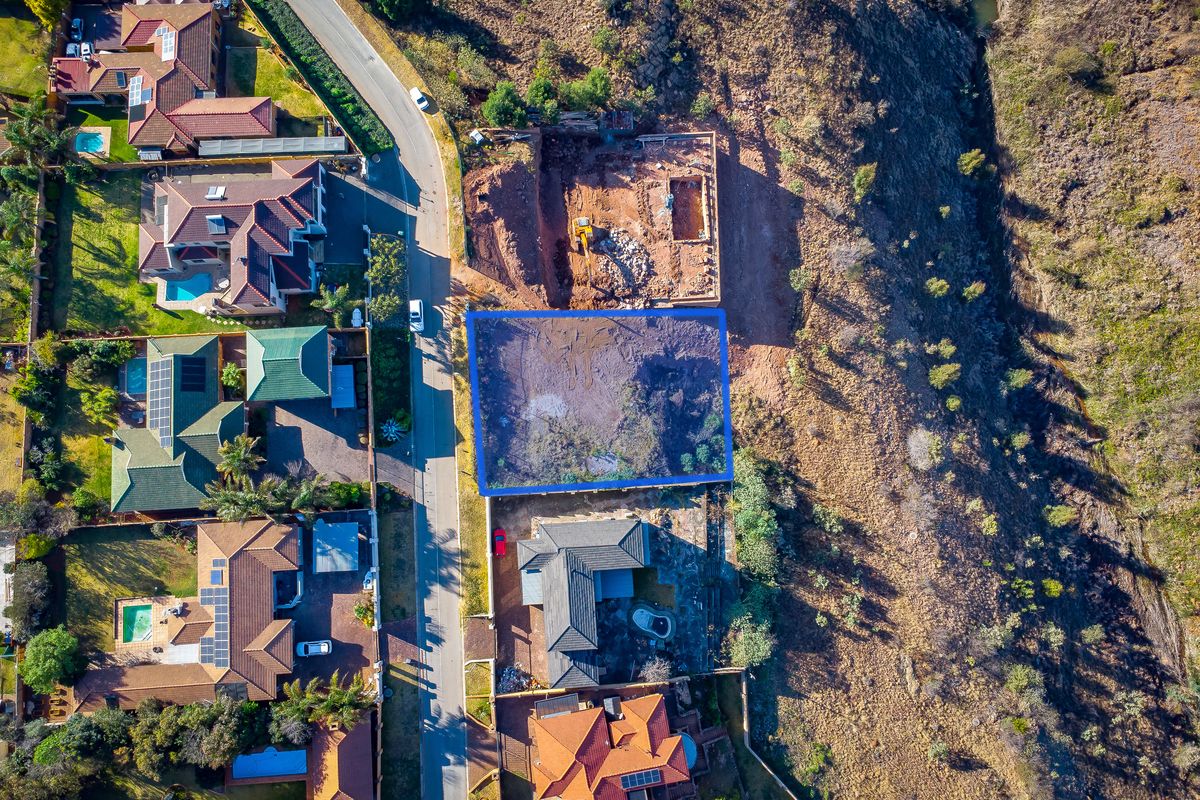 An aerial view of a vacant residential plot situated in a developed neighborhood, highlighting the land boundaries and surrounding residential properties.