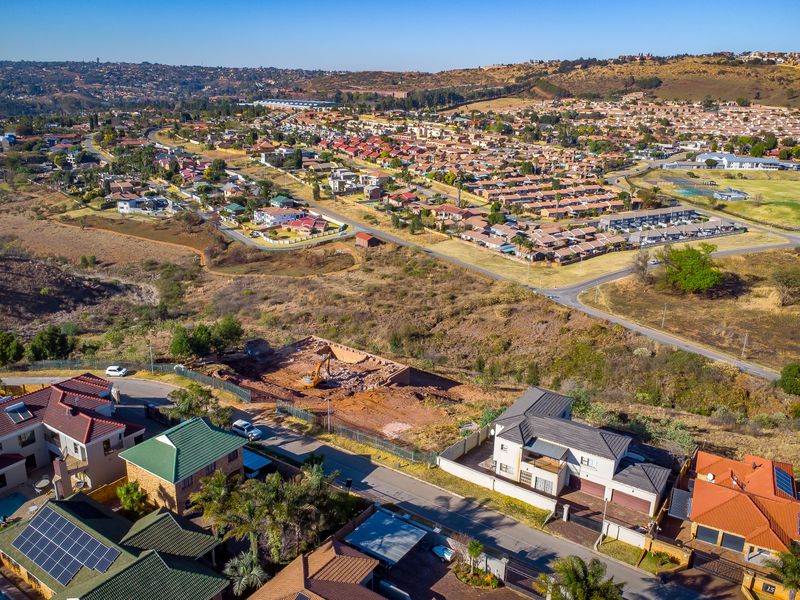 Aerial view of a residential vacant land plot currently undergoing excavation and site preparation within an established suburban neighborhood.