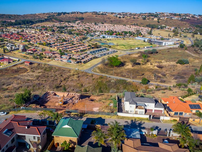 Aerial view of a vacant residential plot situated within an established suburban neighborhood, offering potential for new construction.