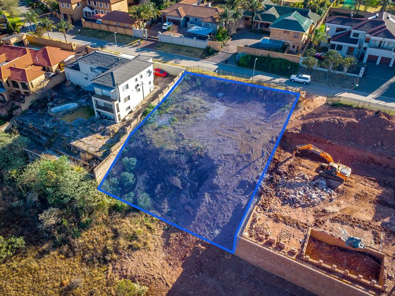 Aerial view of a vacant residential plot with boundary markers, situated in an established suburban neighborhood.