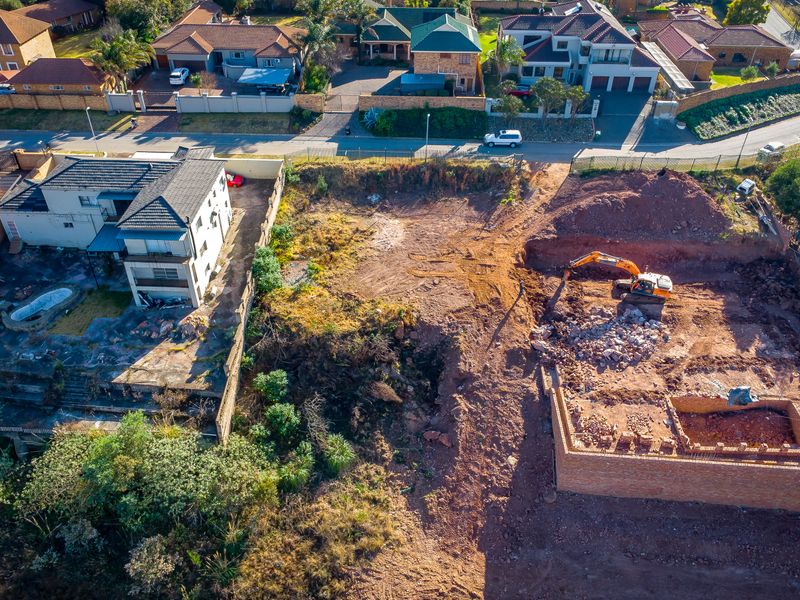 Aerial view of a residential vacant land plot currently undergoing excavation and foundation work for new construction.