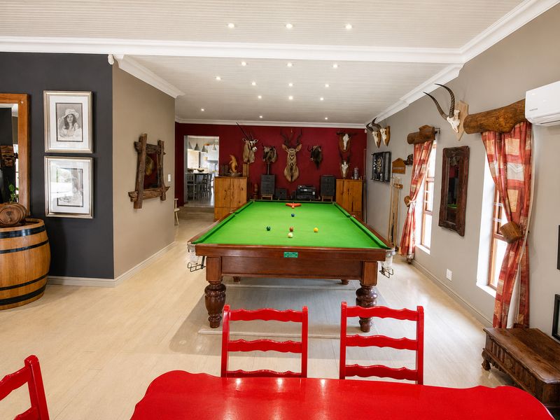 Spacious living area featuring timber flooring, recessed downlighting, and a beadboard ceiling, currently utilized as a games room.