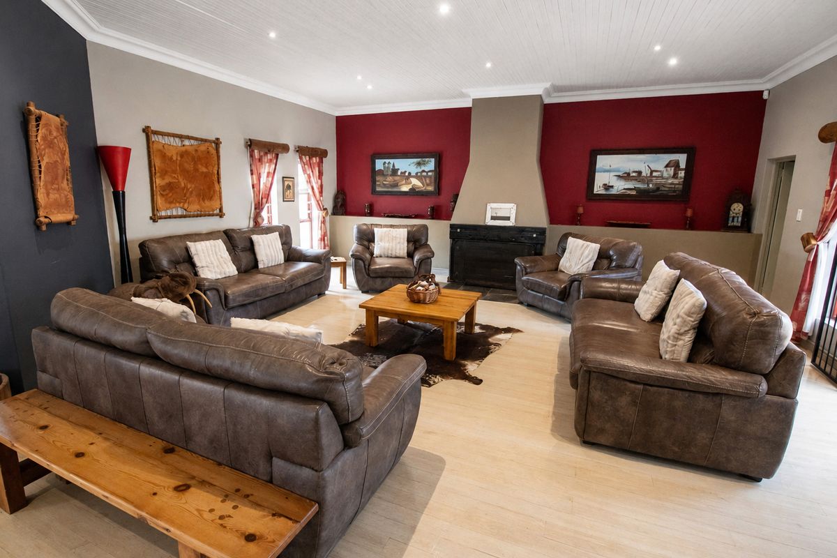 Spacious living room featuring a central fireplace, recessed lighting, and light-toned flooring, offering a comfortable and inviting atmosphere.