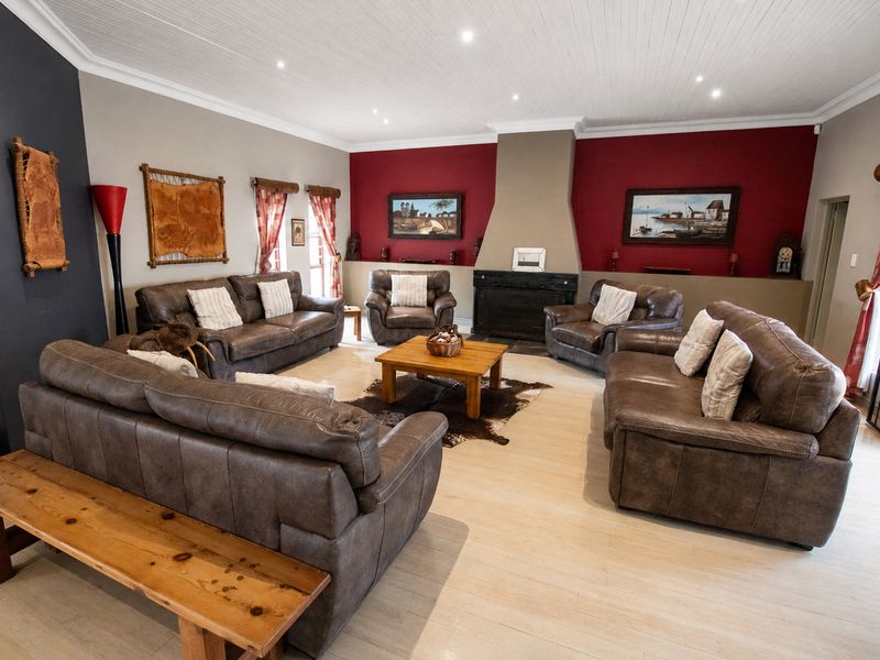 Spacious living room featuring a central fireplace, recessed lighting, and light-toned flooring, offering a comfortable and inviting atmosphere.