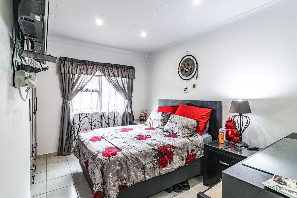 A bedroom featuring tiled flooring, recessed downlighting, and a window with curtain treatments.