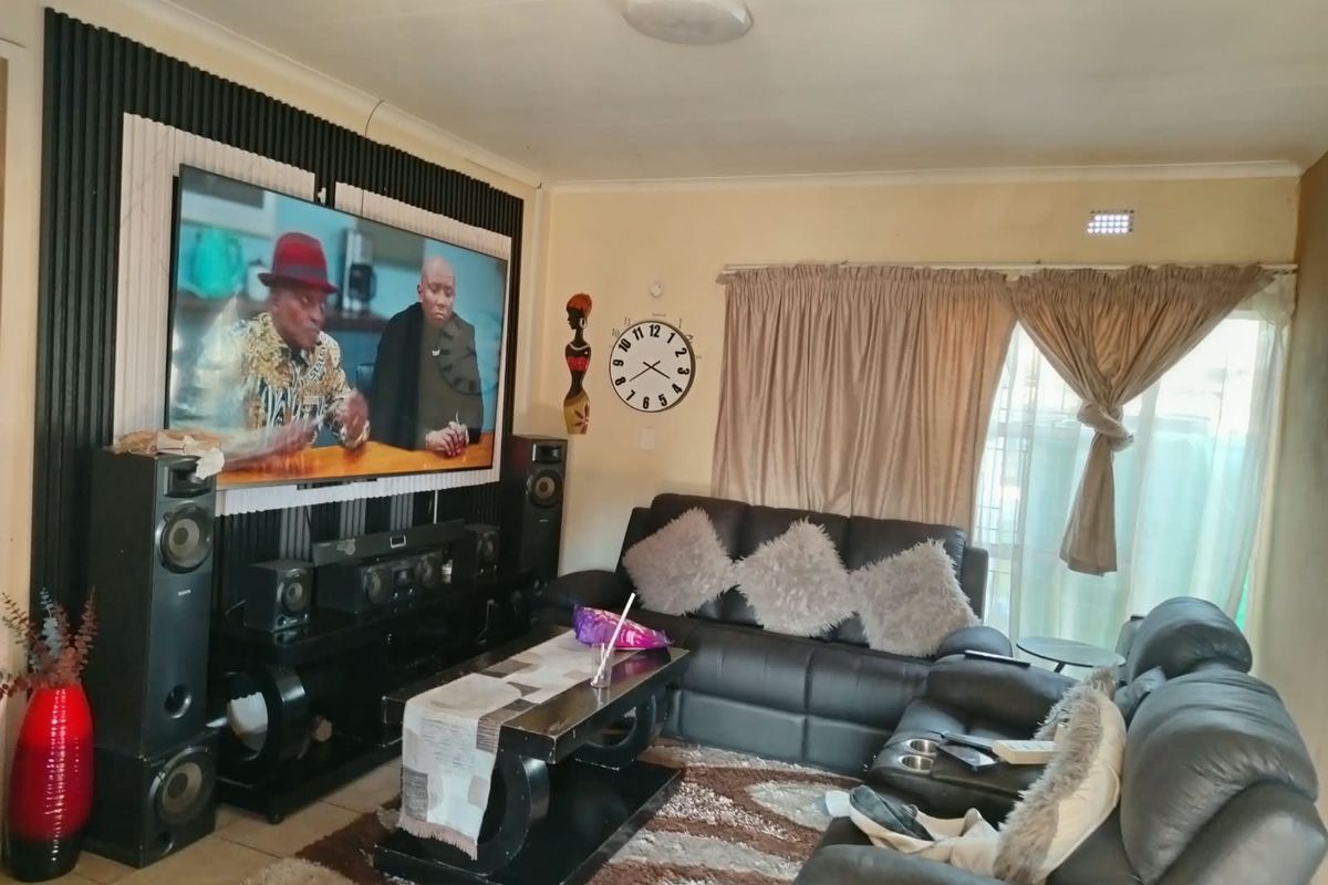 A living room featuring decorative slatted wall paneling and tiled flooring, providing a functional space for relaxation and entertainment.
