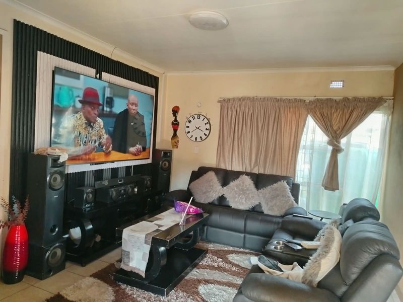 A living room featuring decorative slatted wall paneling and tiled flooring, providing a functional space for relaxation and entertainment.