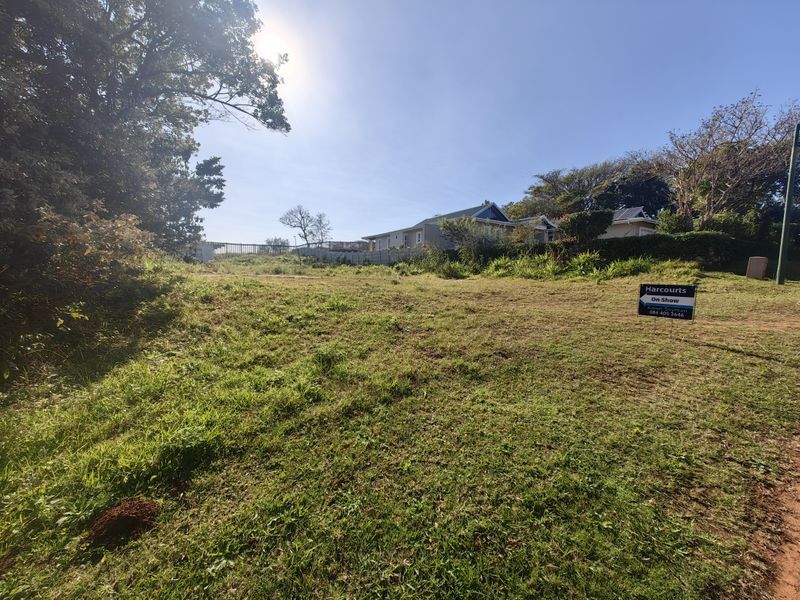 A vacant residential plot featuring natural grass cover and boundary fencing, offering potential for development in a established neighborhood.