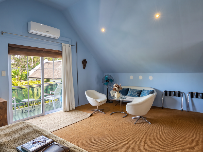 Spacious bedroom featuring vaulted ceilings, air conditioning, and a sliding glass door providing access to a private balcony.