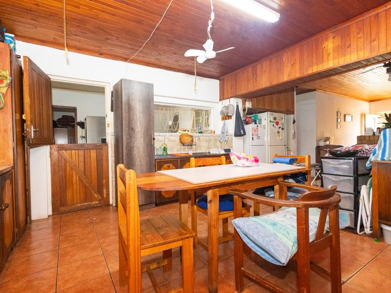Open plan kitchen and dining area featuring wooden ceilings, tiled floors, and traditional stable door access to the rest of the home.
