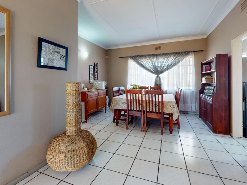 A functional dining room featuring tiled flooring and neutral wall tones, providing a practical space for family meals.