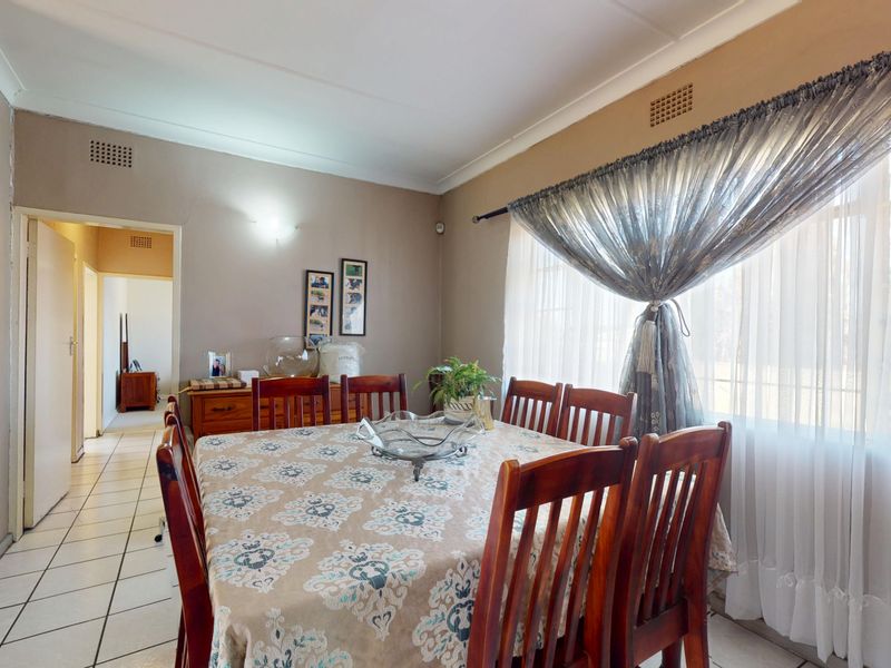 A dining room featuring tiled flooring and classic cornicing, providing a functional space for family meals.
