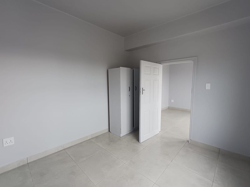 A bright, neutral bedroom featuring tiled flooring and a clean, minimalist aesthetic, ready for personalization.