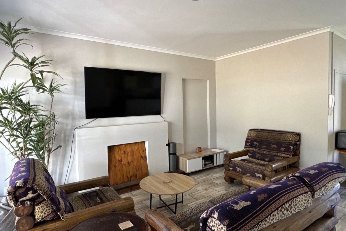 A living room featuring a built-in fireplace, tiled flooring, and coved ceilings, providing a functional and neutral space for relaxation.