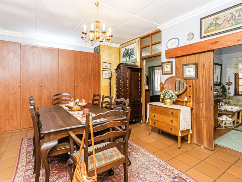 A dining room featuring tiled flooring, built-in wooden cabinetry, and a sliding door providing access to an adjacent bathroom area.