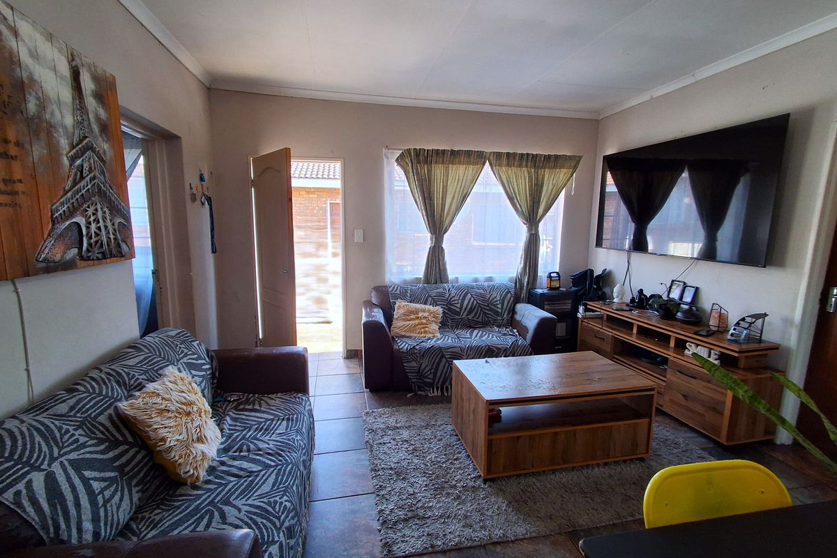 A comfortable living room featuring tiled flooring and direct access to the exterior through a sliding door.