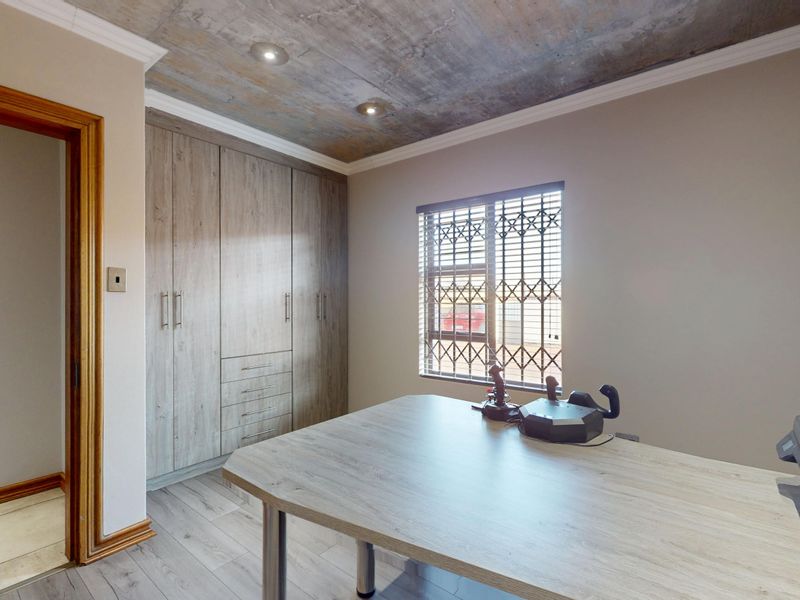 A bedroom featuring built-in cupboards, laminate flooring, and a unique exposed concrete ceiling with recessed lighting.