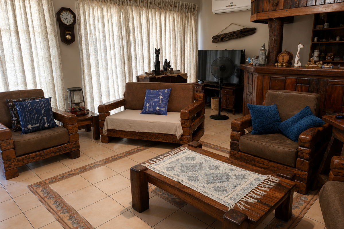 A cozy living room featuring tiled floors with a decorative border, built-in wooden cabinetry, and a wall-mounted air conditioning unit.