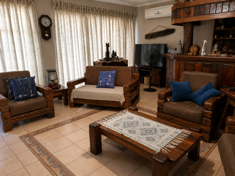 A cozy living room featuring tiled floors with a decorative border, built-in wooden cabinetry, and a wall-mounted air conditioning unit.