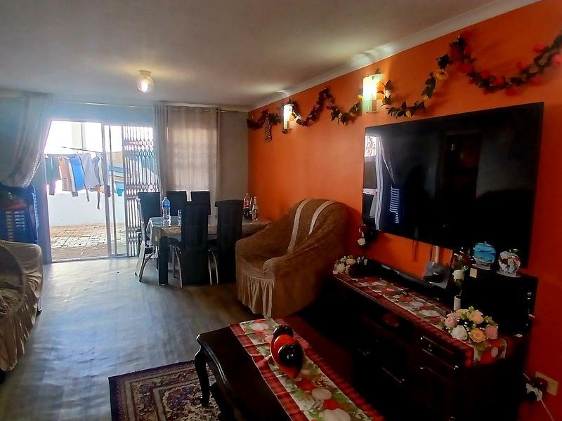 Open-plan living and dining area featuring laminate flooring and sliding glass doors leading to an outdoor space.