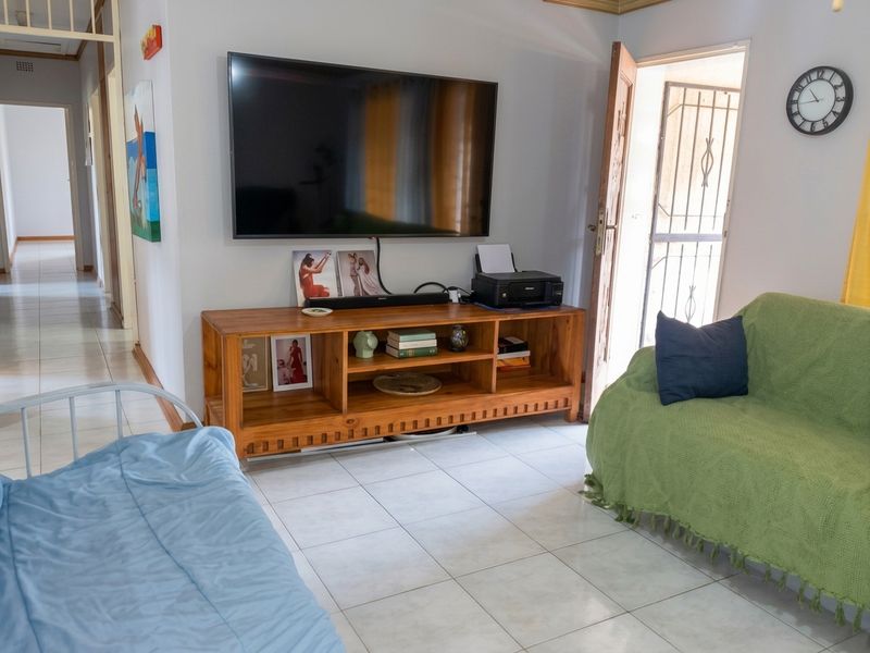 A living room area featuring ceramic floor tiles and direct access to an exterior security gate.
