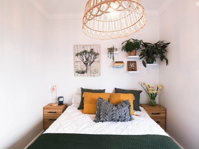 A cozy bedroom featuring neutral walls, crisp white finishes, and a decorative ceiling light fixture.