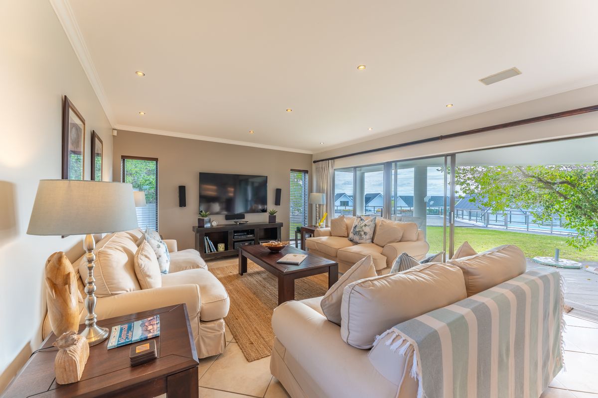 Spacious living room featuring tiled floors, recessed lighting, and large sliding glass doors that provide seamless access to the outdoor patio and garden area.