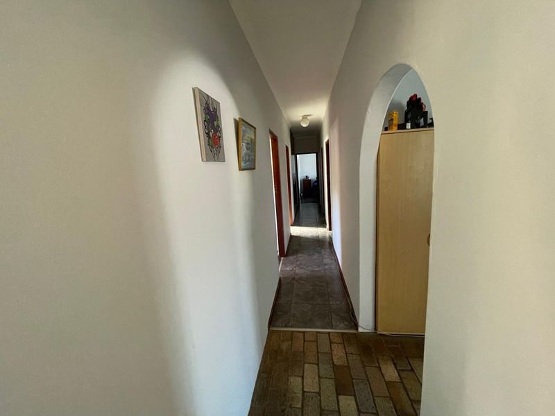 A functional hallway featuring an arched doorway and tiled flooring, providing access to multiple rooms within the home.